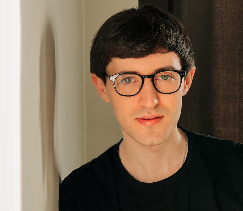 Un ritratto fotografico di Matthew che accenna un sorriso sincero verso chi legge. 