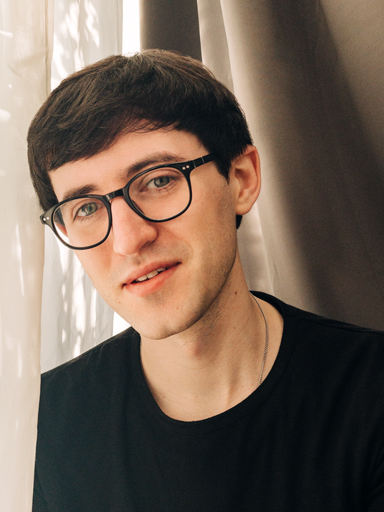 Un ritratto fotografico di Matthew che guarda verso chi legge con uno sguardo pensieroso.
