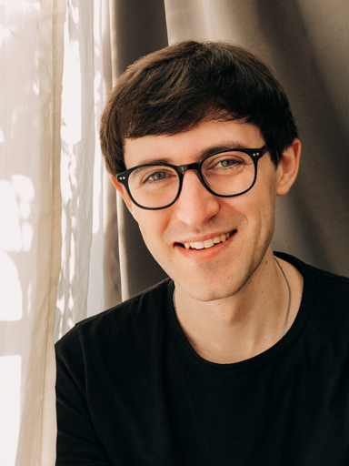 Un ritratto fotografico di Matthew che guarda riflessivo verso chi legge.