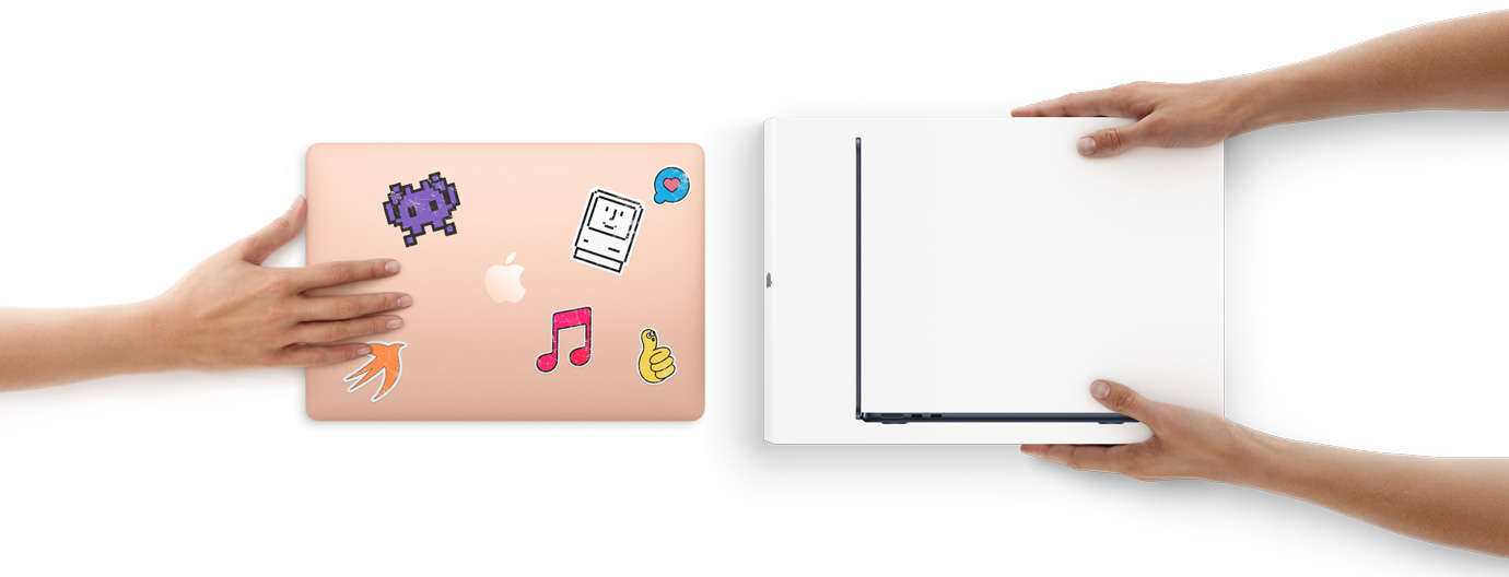 한 손이 윗면에 스티커가 붙은 MacBook을 밀어, 새 MacBook이 든 상자를 들고 있는 두 손 쪽으로 건네는 모습
