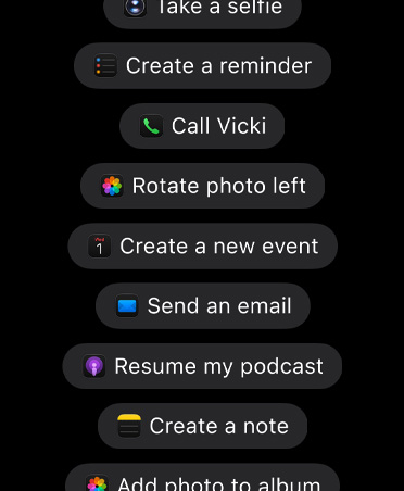 شاشة تعرض طلبات موجّهة إلى Siri AI لاتخاذ إجراءات في التطبيقات، بما في ذلك Take a selfie، وCreate a reminder، وCall Vicki، وRotate photo left، وCreate a new event، وSend an email، وResume my podcast، وCreate a note، وAdd photo to album