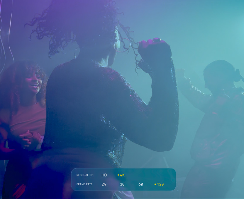Een scherm met een filmopname bij weinig licht van drie dansende mensen om de mogelijkheden van 4K Dolby Vision met 120 bps te demonstreren