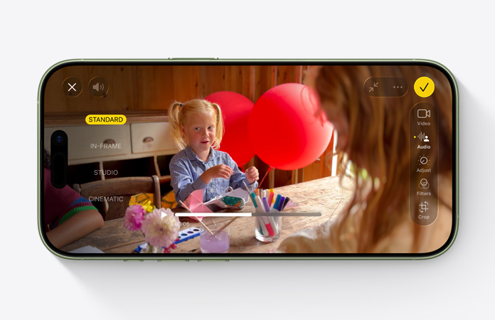 iPhone 17, vedere frontală, videoclip cu funcția Audio Mix activată, copil jucându-se la o masă cu baloane