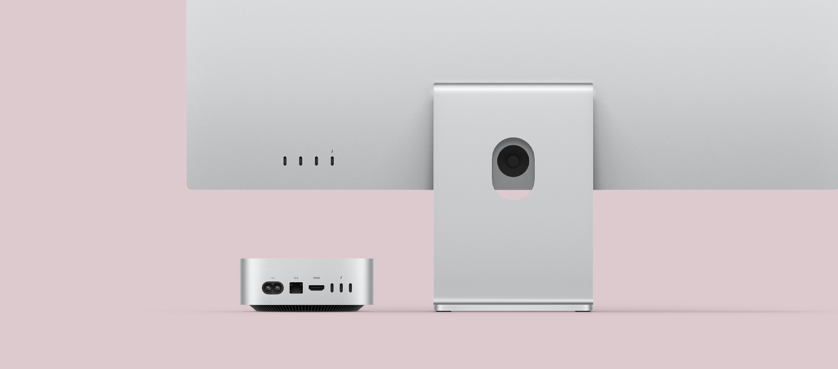 Вид ззаду на сріблястий Mac mini і монітор Mac. На Mac mini, що акуратно розташований під монітором Mac, показано порти на задній панелі