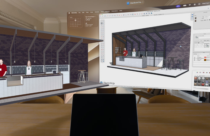 منظر من خلال Apple Vision Pro، جهاز MacBook Pro موضوع على سطح مع نماذج ثلاثية الأبعاد معروضة خلفه، النماذج تعرض طاولة خدمة في مقهى وشخصين يقفان خلفها